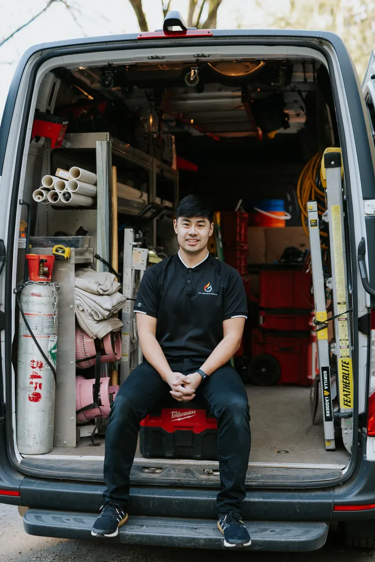 Tony Wong, owner of TAK Heating & Cooling, seated in the back of his service van in Coquitlam
