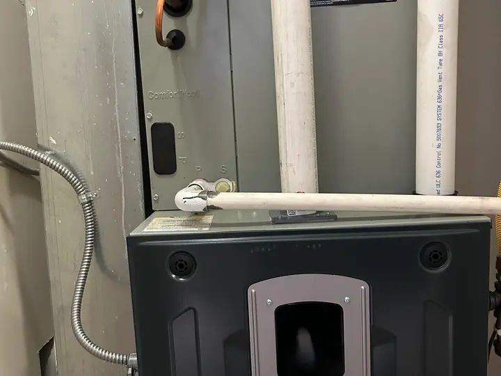 Evaporator coil mounted above a Trane furnace in a residential mechanical room